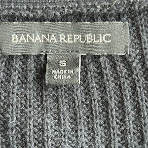 Long “varsity” cardigan, dark navy or black (hard to tell).